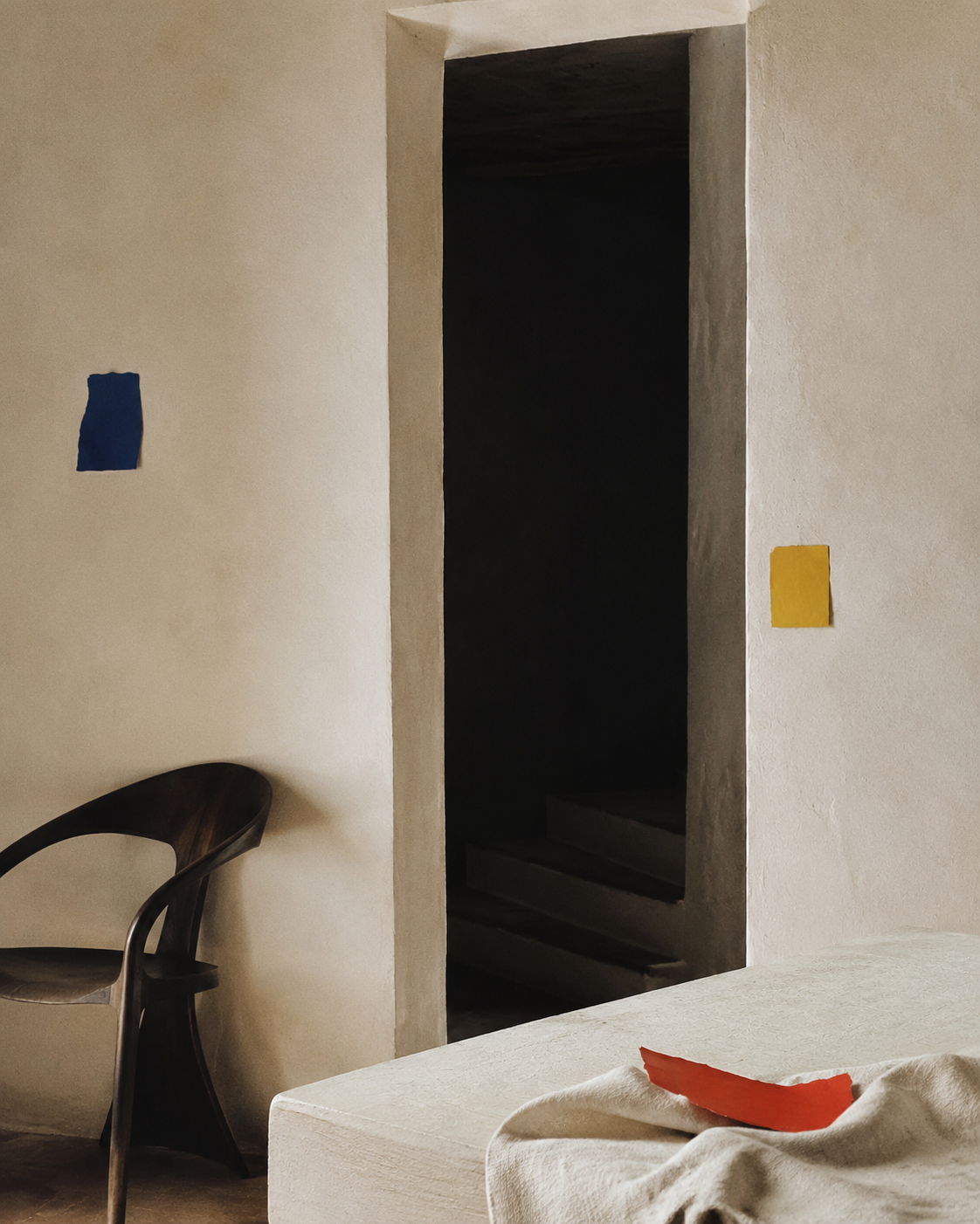 A quiet room with a dark threshold, chair, table and three coloured paper marks